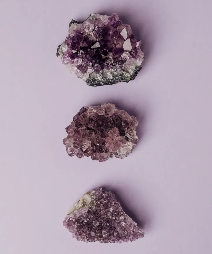 Three amethyst clusters set in a column on a pale lavender ground